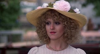 Movie still from “The Jerk” (1979), directed by Carl Reiner – A woman wearing a straw hat with pink flowers on it; Close Up shot, High angle