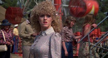 Movie still from “The Jerk” (1979), directed by Carl Reiner – A woman with a blonde curly hair standing in front of other women; Medium shot, Over the shoulder angle