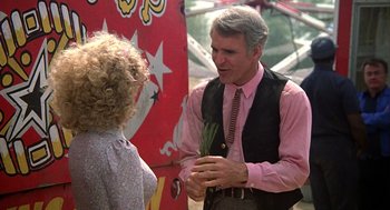 Movie still from “The Jerk” (1979), directed by Carl Reiner – An older man wearing a pink shirt and a pink tie talking to an older woman wearing a pink shirt; Medium shot, Over the shoulder angle