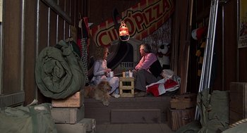 Movie still from “The Jerk” (1979), directed by Carl Reiner – Two people sitting on a porch with a dog; Wide shot, High angle