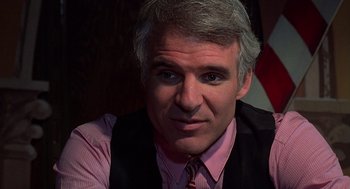 Movie still from “The Jerk” (1979), directed by Carl Reiner – A person wearing a vest and a pink shirt; Close Up shot, Over the shoulder angle