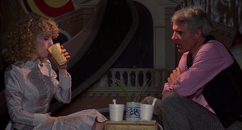 Movie still from “The Jerk” (1979), directed by Carl Reiner – A man and a woman sitting on the ground eating sandwiches; Medium shot, Over the shoulder angle