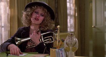 Movie still from “The Jerk” (1979), directed by Carl Reiner – A woman in a black hat holding a trumpet; Close Up shot, Low angle