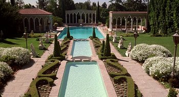 Movie still from “The Jerk” (1979), directed by Carl Reiner – A large pool surrounded by hedges and statues; Extreme Wide shot, High angle