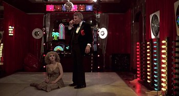 Movie still from “The Jerk” (1979), directed by Carl Reiner – A man and a woman are standing on a stage; Wide shot, Low angle