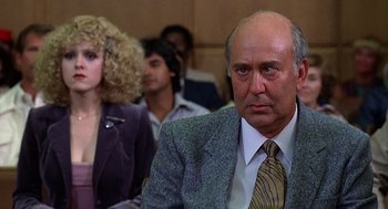 Movie still from “The Jerk” (1979), directed by Carl Reiner – A man in a suit and tie sitting next to a woman; Close Up shot, Over the shoulder angle