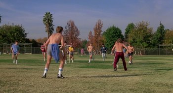 Movie still from “The Karate Kid” (1984), directed by John G. Avildsen – A group of men playing a game of soccer on a field; Wide shot, High angle