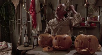 Movie still from “The Karate Kid” (1984), directed by John G. Avildsen – An older man is carving pumpkins for halloween; Medium shot, High angle