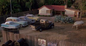 Movie still from “The Karate Kid” (1984), directed by John G. Avildsen – An old truck parked next to a bunch of old cars; Extreme Wide shot, High angle