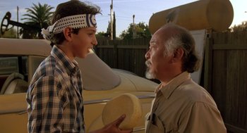 Movie still from “The Karate Kid” (1984), directed by John G. Avildsen – A man and a young boy talking to each other; Close Up shot, Over the shoulder angle