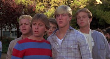 Movie still from “The Karate Kid” (1984), directed by John G. Avildsen – A group of young men standing next to each other in front of trees; Close Up shot, Low angle