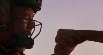 Movie still from “The Karate Kid” (1984), directed by John G. Avildsen – An older man wearing a helmet and holding a baseball glove; Close Up shot, Over the shoulder angle