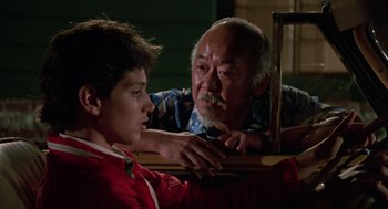 Movie still from “The Karate Kid” (1984), directed by John G. Avildsen – An older man and a young boy looking at each other; Close Up shot, Over the shoulder angle