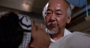 Movie still from “The Karate Kid” (1984), directed by John G. Avildsen – An older man is looking at a remote control; Close Up shot, Over the shoulder angle