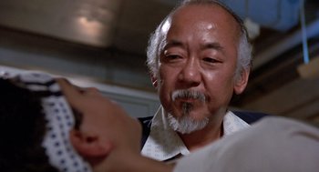 Movie still from “The Karate Kid” (1984), directed by John G. Avildsen – An older man is looking at the camera; Close Up shot, Low angle