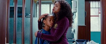 Movie still from “The Karate Kid” (2010), directed by Harald Zwart – A woman is hugging a young girl in a room; Close Up shot, Over the shoulder angle