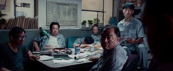 Movie still from “The Karate Kid” (2010), directed by Harald Zwart – A group of people sitting around a table; Wide shot, High angle
