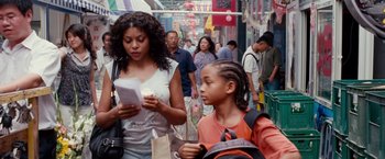 Movie still from “The Karate Kid” (2010), directed by Harald Zwart – A group of people walking down a street; Medium shot, Over the shoulder angle