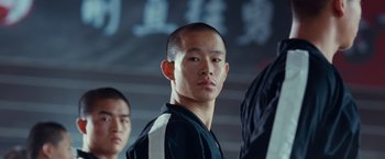 Movie still from “The Karate Kid” (2010), directed by Harald Zwart – A man with a shaved head and a black shirt; Close Up shot, Low angle