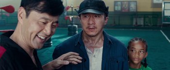 Movie still from “The Karate Kid” (2010), directed by Harald Zwart – A man wearing a hat and a blue jacket; Close Up shot, Over the shoulder angle