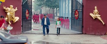Movie still from “The Karate Kid” (2010), directed by Harald Zwart – A man and a boy walking down a street; Wide shot, High angle