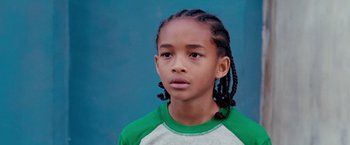 Movie still from “The Karate Kid” (2010), directed by Harald Zwart – A young boy with a green and white t - shirt; Close Up shot, High angle