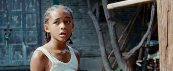 Movie still from “The Karate Kid” (2010), directed by Harald Zwart – A young girl in a white tank top is holding a baseball bat; Close Up shot, Over the shoulder angle