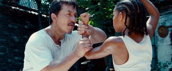 Movie still from “The Karate Kid” (2010), directed by Harald Zwart – A man and a woman are fighting in a ring; Medium shot, Low angle