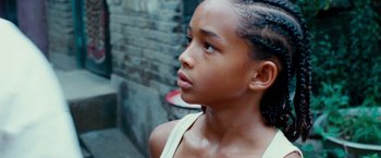Movie still from “The Karate Kid” (2010), directed by Harald Zwart – A young girl looking to her left while standing outside; Close Up shot, Over the shoulder angle