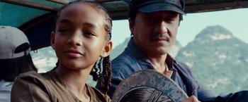 Movie still from “The Karate Kid” (2010), directed by Harald Zwart – A man and a girl are standing next to each other; Close Up shot, Low angle
