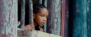 Movie still from “The Karate Kid” (2010), directed by Harald Zwart – A little girl looking out of a window; Close Up shot, Low angle