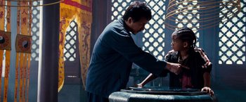 Movie still from “The Karate Kid” (2010), directed by Harald Zwart – A man and a child are standing in front of a fountain; Medium shot, Over the shoulder angle