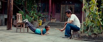 Movie still from “The Karate Kid” (2010), directed by Harald Zwart – A man and a little girl are playing a game; Wide shot, High angle