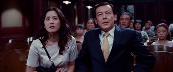 Movie still from “The Karate Kid” (2010), directed by Harald Zwart – A man and a woman standing next to each other in a crowd; Medium shot, Low angle