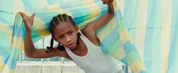 Movie still from “The Karate Kid” (2010), directed by Harald Zwart – A young girl holding onto a blue and yellow umbrella; Close Up shot, Low angle