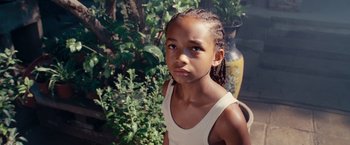 Movie still from “The Karate Kid” (2010), directed by Harald Zwart – A little girl standing next to some plants; Close Up shot, High angle