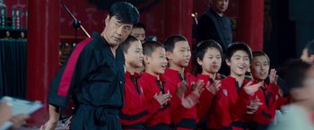 Movie still from “The Karate Kid” (2010), directed by Harald Zwart – A group of young boys in red and black shirts; Medium shot, Low angle