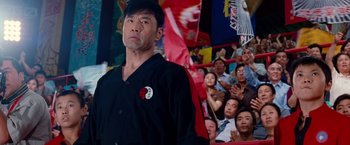 Movie still from “The Karate Kid” (2010), directed by Harald Zwart – A man standing in front of a group of people; Medium shot, Low angle