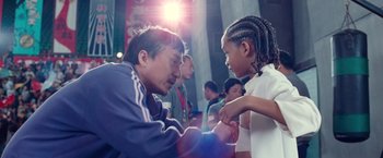 Movie still from “The Karate Kid” (2010), directed by Harald Zwart – A man and a girl are looking at each other; Medium shot, Over the shoulder angle