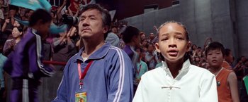 Movie still from “The Karate Kid” (2010), directed by Harald Zwart – A man and a boy standing next to each other in front of a crowd of people; Close Up shot, Low angle