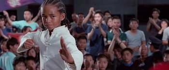 Movie still from “The Karate Kid” (2010), directed by Harald Zwart – A group of people watching a young boy perform a martial arts move; Close Up shot, Low angle