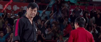 Movie still from “The Karate Kid” (2010), directed by Harald Zwart – Two men standing next to each other in front of an audience; Medium shot, Over the shoulder angle