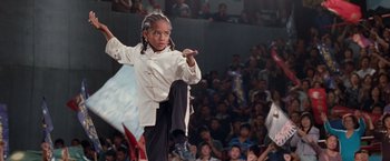 Movie still from “The Karate Kid” (2010), directed by Harald Zwart – A young boy is performing martial arts in front of an audience; Medium shot, Low angle