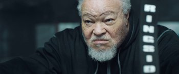 An older man with a beard and a black jacket