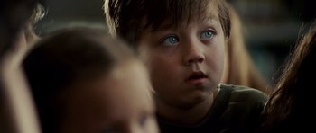 Movie still from “The Kingdom” (2007), directed by Peter Berg – A child with blue eyes; Close Up shot, Over the shoulder angle