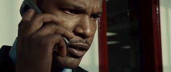 Movie still from “The Kingdom” (2007), directed by Peter Berg – A person talking on a cell phone; Extreme Close Up shot, Low angle