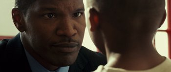 Movie still from “The Kingdom” (2007), directed by Peter Berg – A person with a suit and tie; Close Up shot, Over the shoulder angle