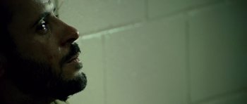Movie still from “The Kingdom” (2007), directed by Peter Berg – A man with a beard is looking into a mirror; Close Up shot, High angle