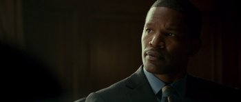 Movie still from “The Kingdom” (2007), directed by Peter Berg – A person wearing a suit and tie; Close Up shot, Over the shoulder angle