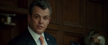 Movie still from “The Kingdom” (2007), directed by Peter Berg – A person wearing a suit and tie; Close Up shot, Over the shoulder angle